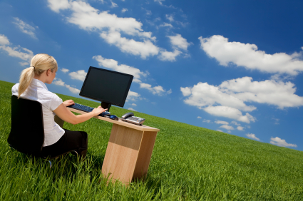 Businesswoman Using Computer In A Green Field